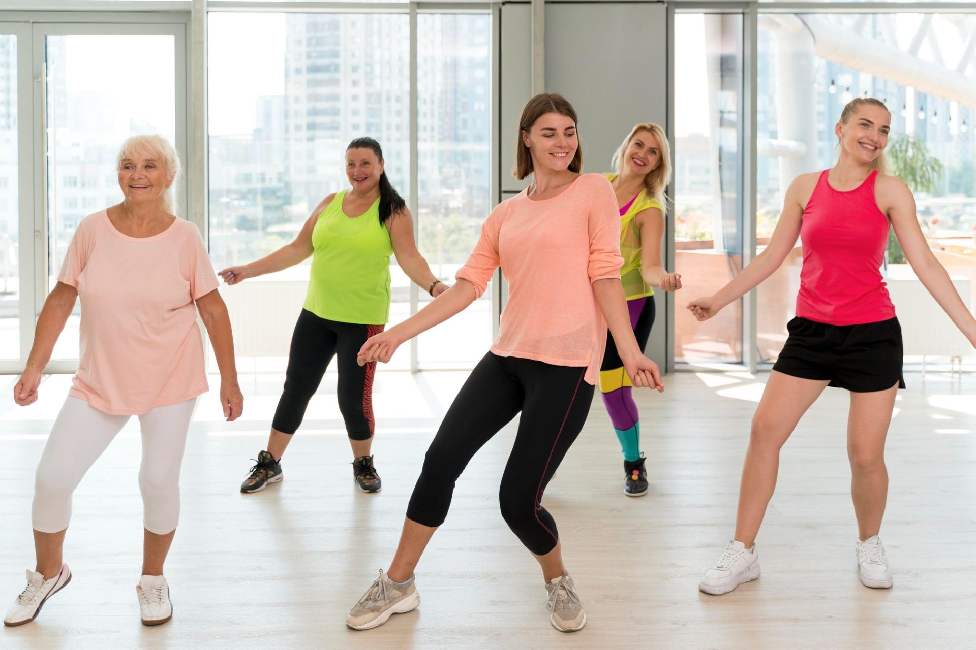 Osoby na sali tańczą zumbę